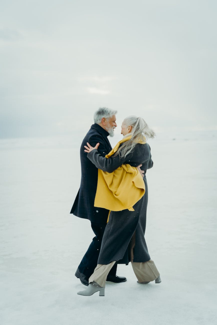 happy couple dancing on snow how to embrace grey hair how to embrace gray hair how to embrace going grey how to embrace going gray how to accept your grey hair how to accept your gray hair